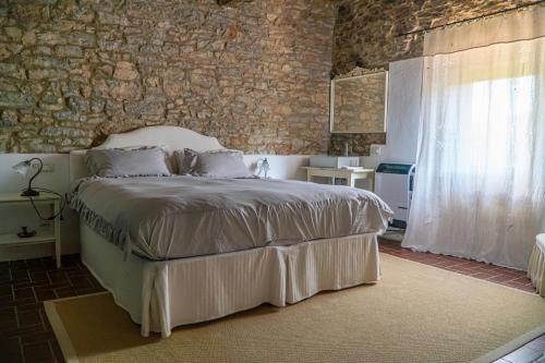 a bedroom with a bed and a brick wall at Piccozzo agritour in Casciana Terme