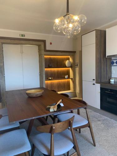 a kitchen with a wooden table and some chairs at Quinta das Fontes in Poças do Monte