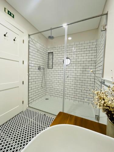 a bathroom with a shower with a glass door at Quinta das Fontes in Poças do Monte