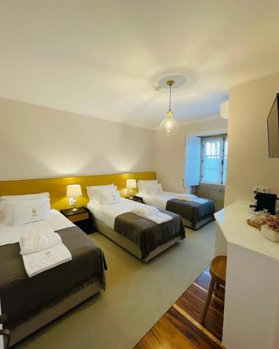 a hotel room with two beds and two tables at Quinta das Fontes in Poças do Monte