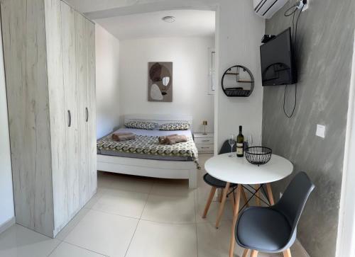 a small bedroom with a bed and a table at Apartments AS in Budva