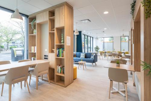 an office with tables and chairs and a book shelf at Oh Activ Cergy in Cergy