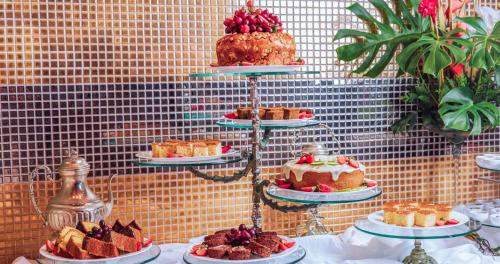 a display of cakes and pastries on plates on a table at DPNY Beach Hotel & SPA Ilhabela in Ilhabela