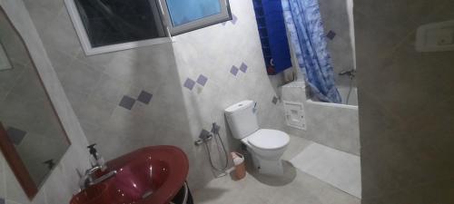 a bathroom with a red sink and a toilet at Casa loud in Sidi el Moujahed
