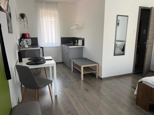 a small room with a table and a kitchen at Sophia Apartman Gödöllő in Gödöllő