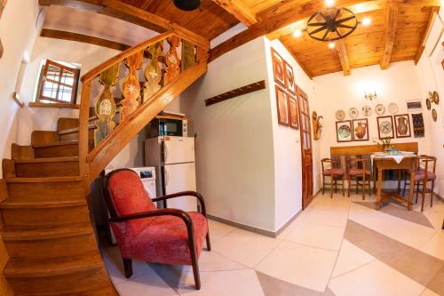 a living room with a staircase and a table and chairs at Cserépmadár szállás és Csinyálóház in Velemér