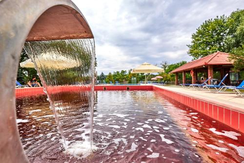 a water fountain in front of a swimming pool at Silver Major in Kaba