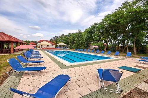 a group of blue chairs and a swimming pool at Silver Major in Kaba