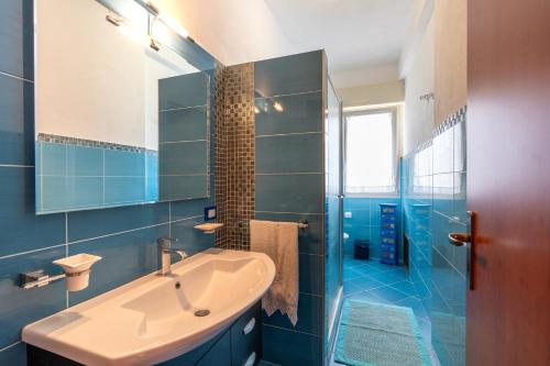 a blue bathroom with a sink and a tub at Villa Margi in Scopello