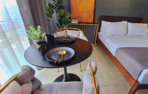 a small room with a table with a bed and a bed and a bed at The French Apartment Pasig - Fast Wi-Fi and pool in Manila