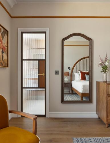 a bedroom with a mirror and a bed at Miiro Le Grand Hôtel Cayré in Paris