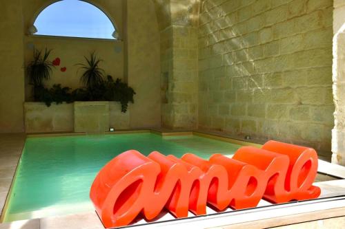 a pool with orange chairs in front of a swimming pool at LeVolte luxury suite&spa in Sternatia