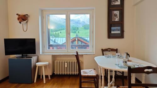 jadalnia ze stołem i oknem w obiekcie Hostdomus - Fox Suite w mieście Sestriere
