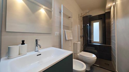 a white bathroom with a sink and a toilet at Hostdomus - Fox Suite in Sestriere