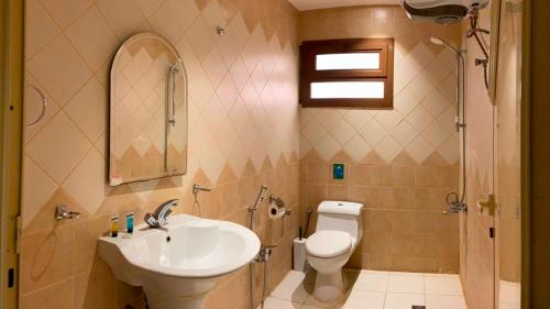 a bathroom with a sink and a toilet at Amaken Aparthotel in Al Ahsa