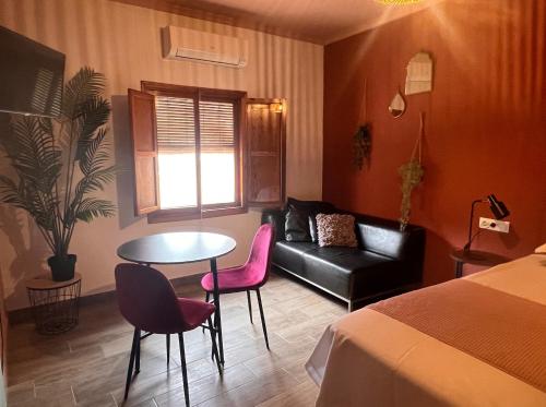 a room with a bed and a table and a couch at Casa de Los Lirios in Muro de Alcoy