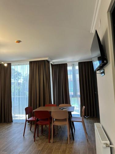 a dining room with a table and chairs and a television at Aparthotel Alfa in Ureki