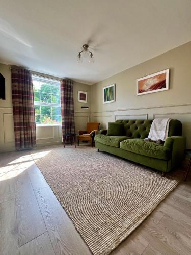 a living room with a green couch and a rug at Luxury Apartment in Rostrevor in Rostrevor