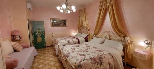 a bedroom with two beds and a couch and a chandelier at Bellavista Versilia in Pietrasanta
