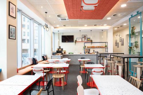 a restaurant with tables and chairs and a counter at ibis budget Leuven Centrum in Leuven