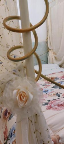 a white rose on a bed with a flower at Bellavista Versilia in Pietrasanta