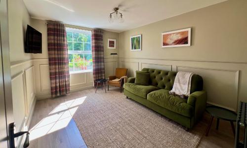 a living room with a green couch and a window at Luxury Apartment in Rostrevor in Rostrevor
