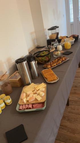 Una mesa con muchos tipos diferentes de comida sobre ella. en Au relais des diligences, en Mézières-en-Vexin