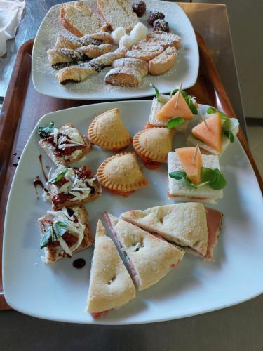 two plates of sandwiches and pastries on a tray at Bellavista Versilia in Pietrasanta