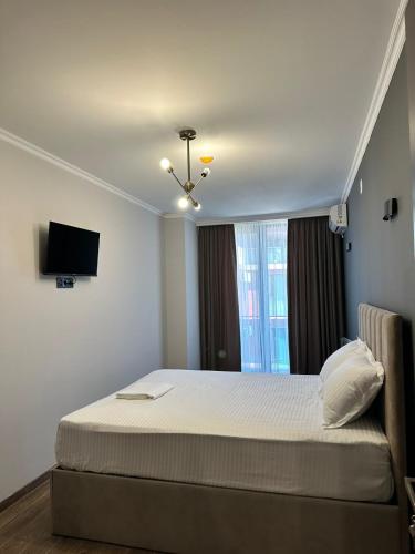 a bedroom with a bed and a television in it at Aparthotel Alfa in Ureki