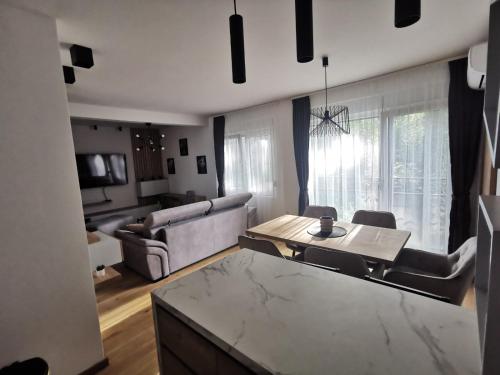 a living room with a table and a couch at Centar Park Lux in Vrnjačka Banja