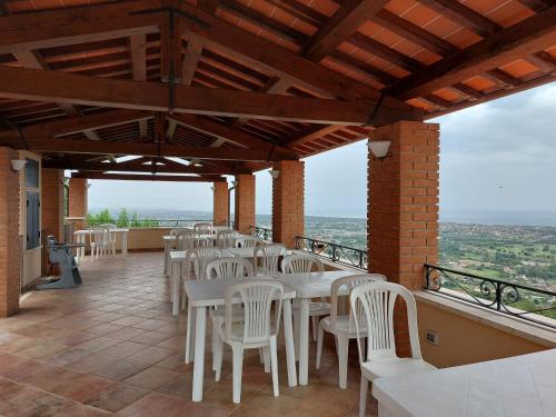 a restaurant with white tables and chairs on a balcony at Bellavista Versilia in Pietrasanta