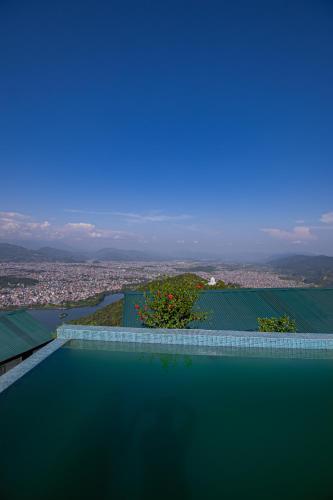 a swimming pool with a view of a city at Raniban Retreat in Pokhara