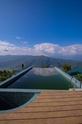 a swimming pool with a view of the mountains at Raniban Retreat in Pokhara