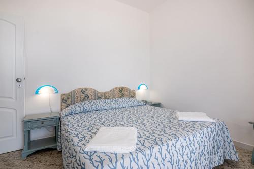 a bedroom with a bed with a blue and white comforter at Hotel Poseidon in Diamante