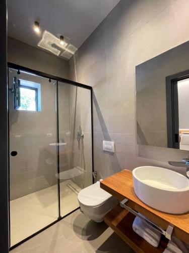 デルミにあるVilla27 Dhermiのトイレ、洗面台、シャワー付きのバスルーム