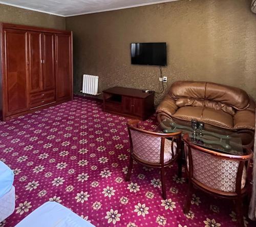 a hotel room with a couch and a television at ОРДА in Shymkent