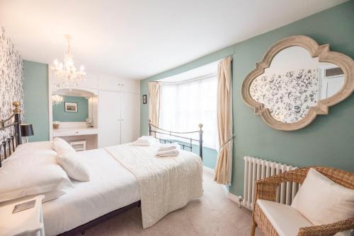 a bedroom with a bed and a mirror on the wall at Oriel Cottage, Aldeburgh in Aldeburgh