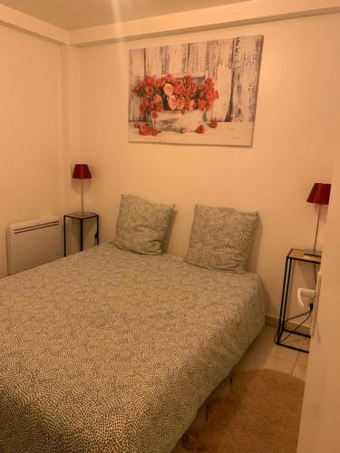 une chambre avec un lit avec deux oreillers dans l'établissement La Maison des roses, à Nanterre
