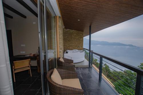 a balcony with chairs and a view of the ocean at Raniban Retreat in Pokhara