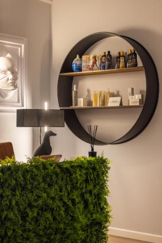 a mirror hanging on a wall with a green hedge at ReMia Suites & Leisure in Alassio
