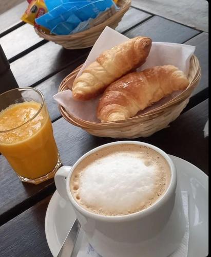 a table topped with a cup of coffee and croissants at Hotel Parque in Villa Mercedes