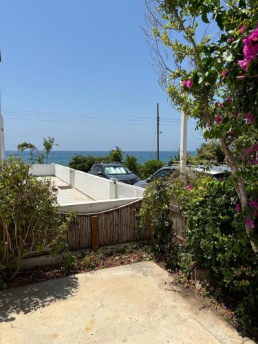 a house with a fence and cars in a parking lot at Seaview Sanctuary House in Larnaka