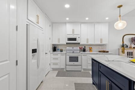 a white kitchen with white cabinets and a refrigerator at Fishermans Landing on The Bay- Las Marinas in South Padre Island