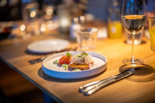 a table with a plate of food and a glass of wine at Hestraviken Hotell & Spa in Hestra