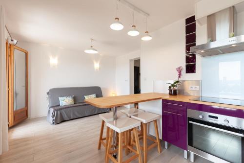une cuisine et un salon avec une table et des placards violets dans l'établissement Vue mer, à La Ciotat