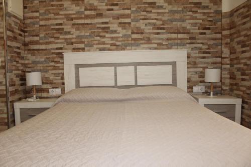 a bedroom with a large bed with two nightstands and two lamps at Estupendo Loft Plaza de Toros in Alicante