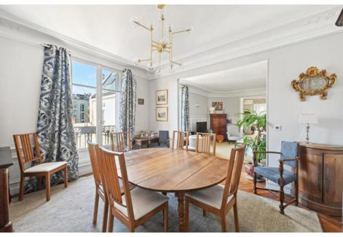 une salle à manger avec une table et des chaises dans l'établissement Veeve - Palatial by the Park, à Paris