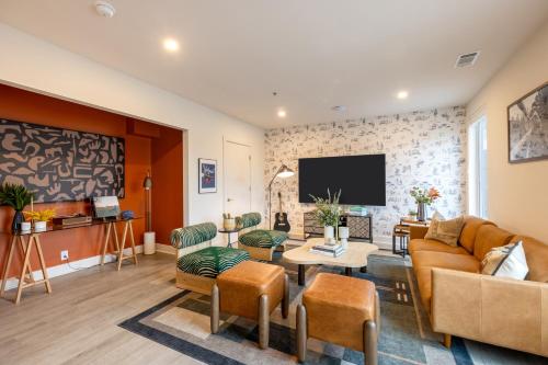 a living room with a couch and a tv at The Outrider by AvantStay in Nashville