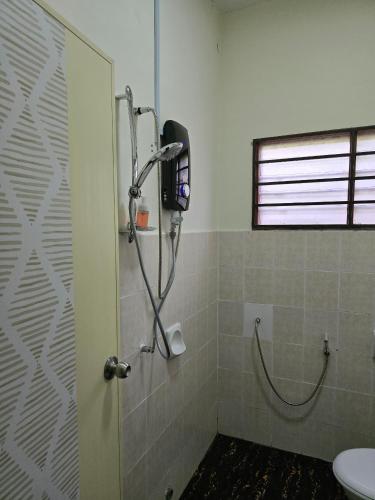 a bathroom with a shower with a toilet and a window at forest villa in Seri Kembangan