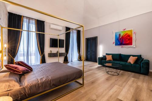 a bedroom with a four poster bed and a couch at ReMia Suites & Leisure in Alassio